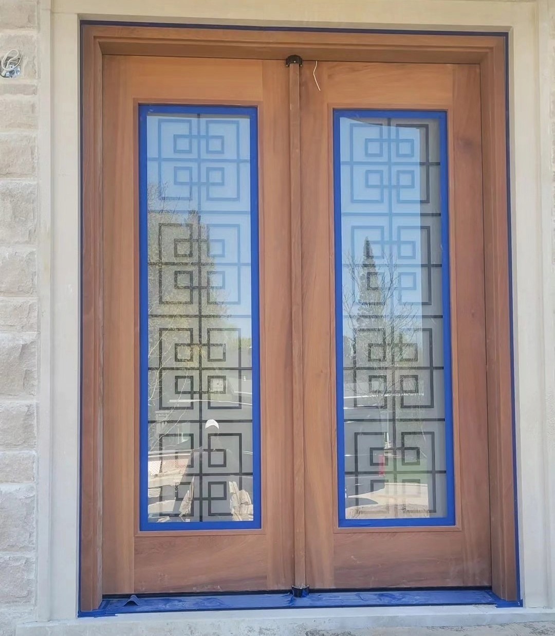 Natural wood double front doors masked for painting
